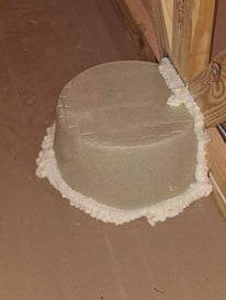 A can light cover in an attic.