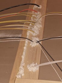 An attic floor with wires, air-sealed and prepped for blown-in insulation using can foam.