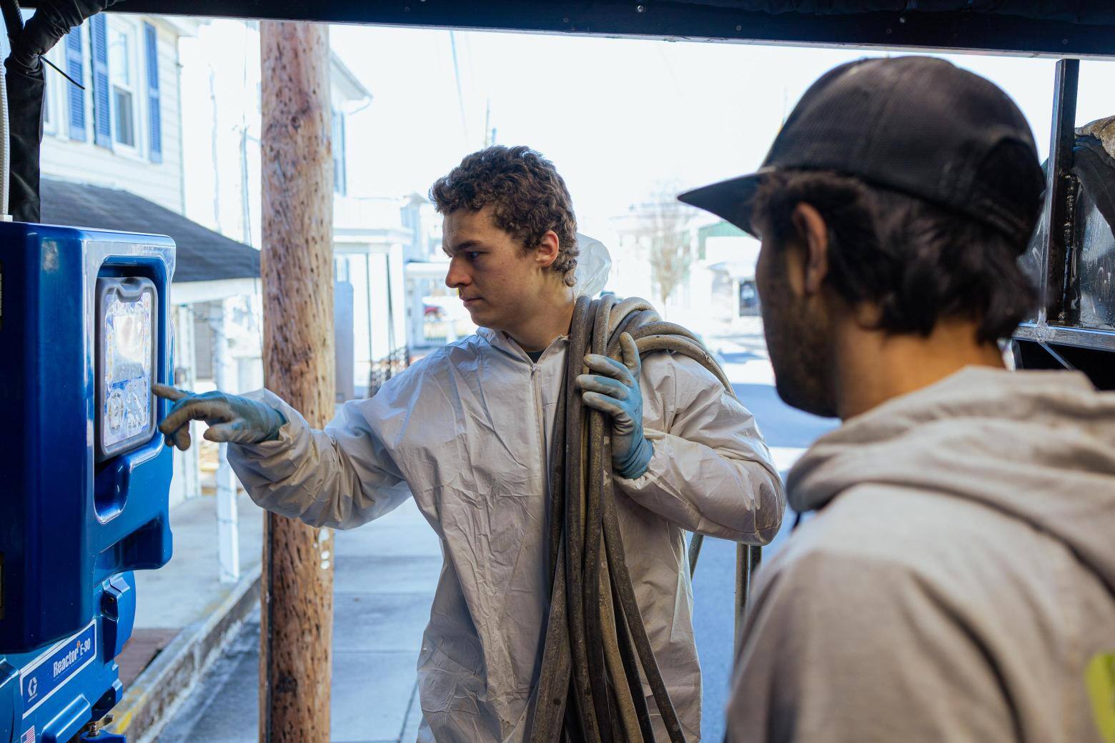 Crew members at South Central Services adjusting the spray foam rig proportioner on site at a job in Chambersburg, Pennsylvania.