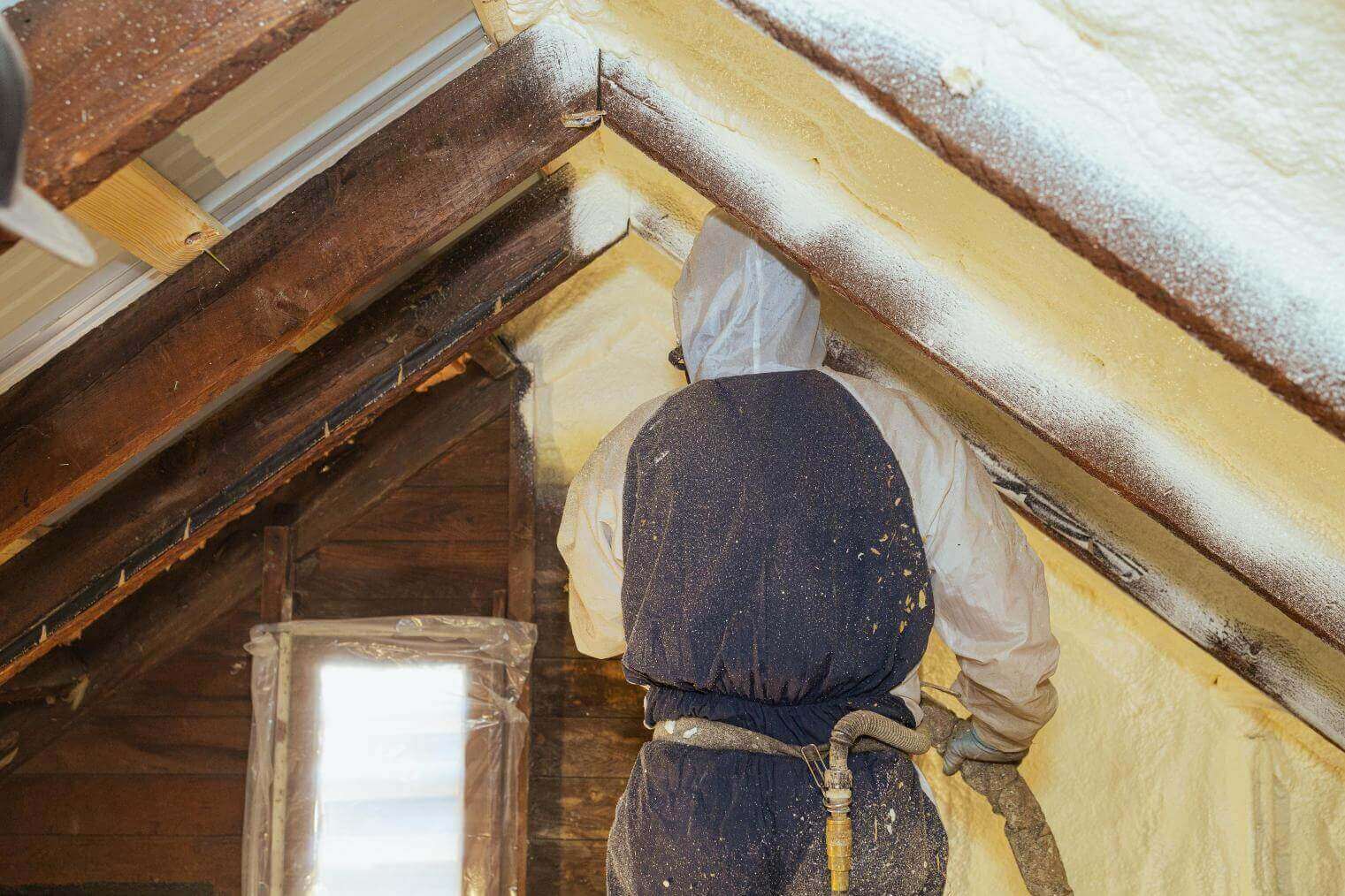 A spray foam installer at South Central Services spraying closed cell foam onto an attic gable in Chambersburg, Pennsylvania.