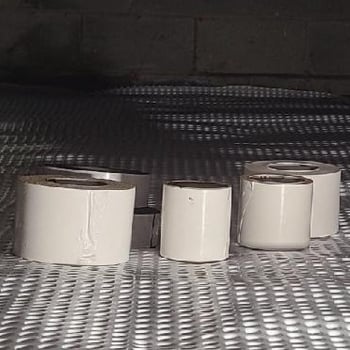 Rolls of professional tape used in crawl space encapsulation, sitting on a layer of dimple mat.