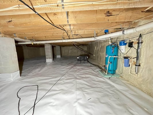 An encapsulated crawl space with plumbing and a dehumidifier.