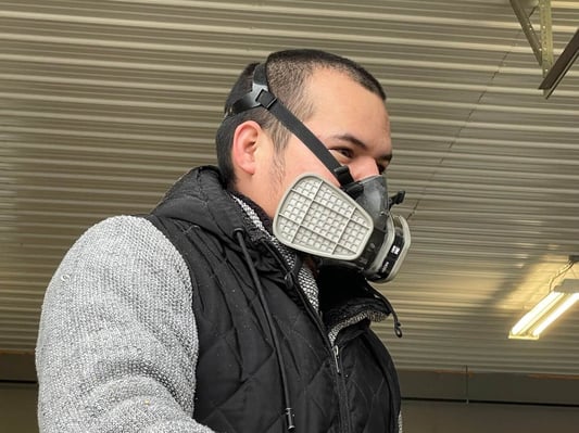 A spray foam crew member modeling a half face respirator.