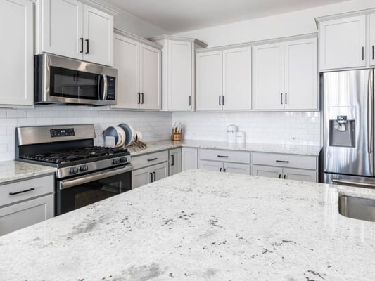 A modern kitchen with granite countertops and stainless steel appliances.