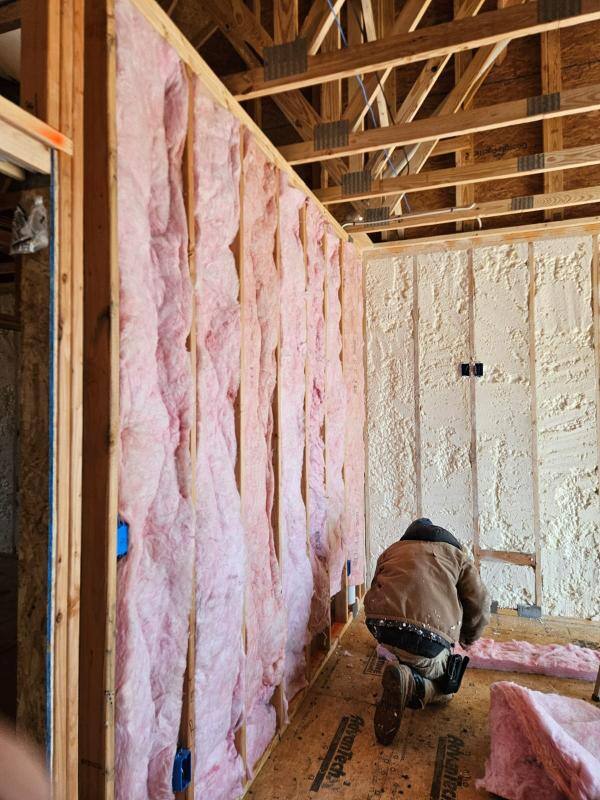 Installing fiberglass batt in the interior wall of a new construction home in Sharpsburg, Maryland.