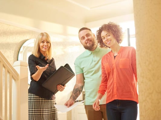 A couple touring a home with a realtor.