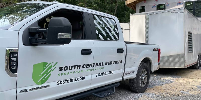 A spray foam insulation rig from South Central Services, on-site at a job location.