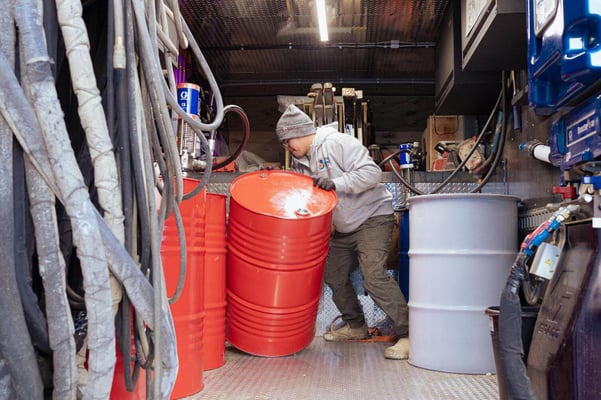 The interior of South Central Services' spray foam rig. A team member puts a spray foam component drum in place on the rig.