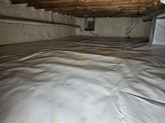 A crawl space encapsulated with closed cell spray foam insulation and a plastic vapor barrier sheathing.