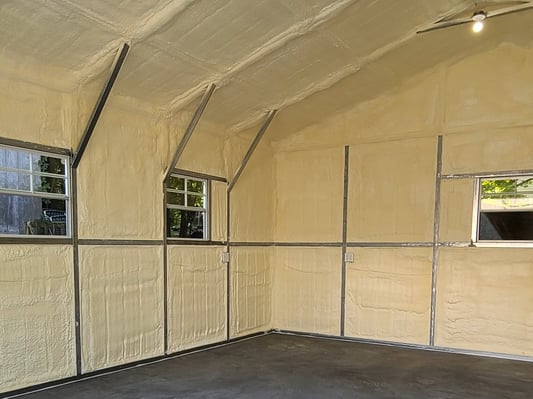 A metal pole building, its walls and ceiling insulated with closed cell spray foam.