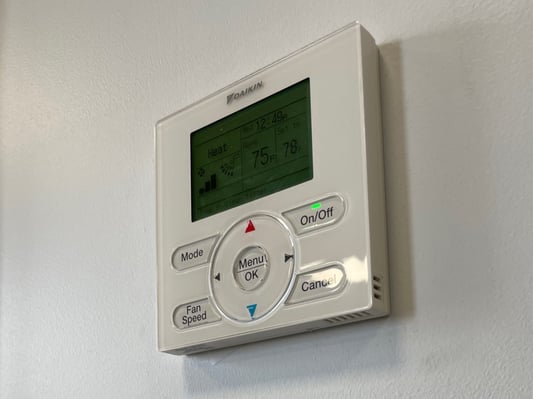 A thermostat mounted to a wall.