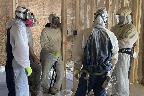 Several spray foam insulation contractors discussing insulation in a new construction home.