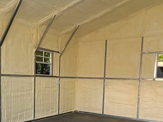 A pole building insulated with closed cell spray foam. The walls and the underside of the roof are covered with insulation.