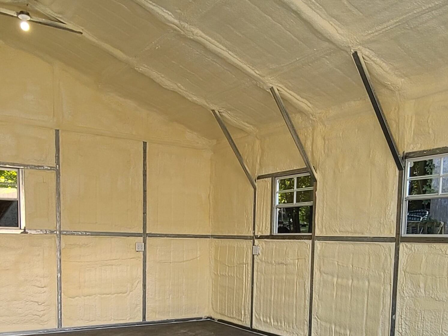 A metal building insulated with closed cell spray foam insulation. The walls and roof have been sprayed with closed cell foam.