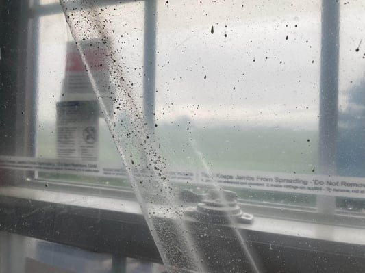 A sheet of plastic covering a new window in a new construction home, to protect the window from spray foam overspray.