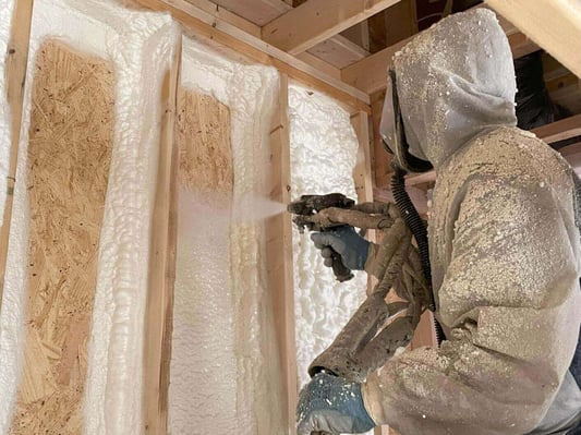 A spray foam insulation contractor installing open cell spray foam in a new construction home.