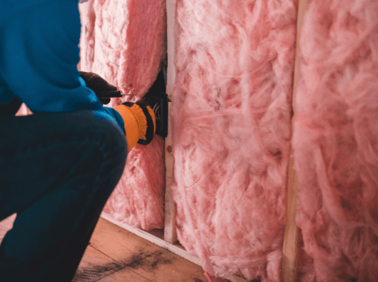 An insulation contractor installing the batt portion of flash and batt insulation.