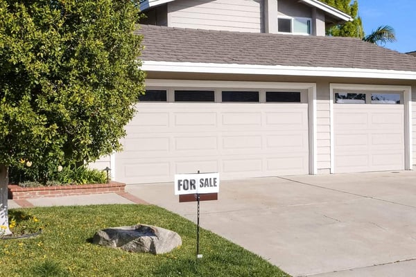 A home with a For Sale sign in the front yard.