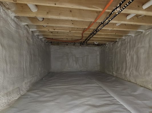 A crawl space encapsulated with closed cell spray foam insulation and thick plastic sheathing.