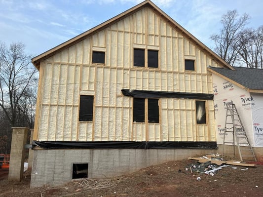 The exterior walls of a new construction rebuilt barn home, insulated with closed cell spray foam.