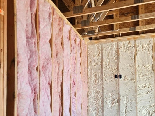 Interior and exterior walls in a new construction home. The interior walls are insulated with fiberglass batt, while the exterior are insulated with open cell spray foam.
