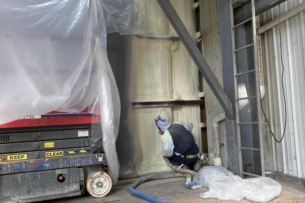 A spray foam insulation contractor insulating a commercial feed mill in Pennsylvania.