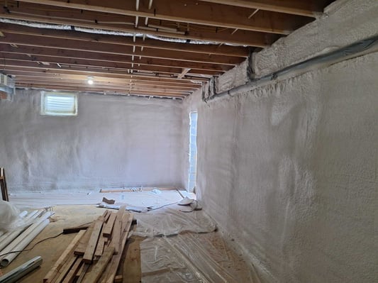 A basement insulated with closed cell spray foam. The masonry walls received a spray-applied insulation for a seamless application.