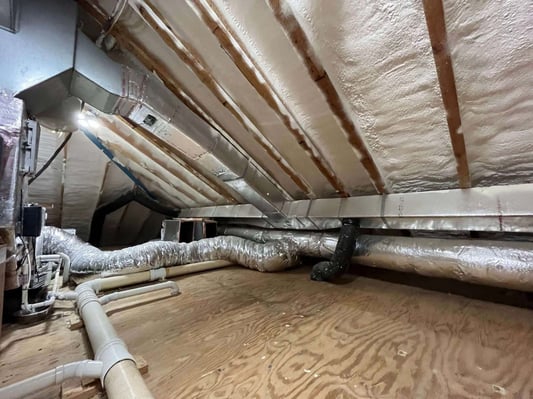An unvented attic with HVAC ductwork, insulated with spray foam.