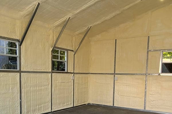A metal building insulated with closed cell spray foam on the walls and ceiling.