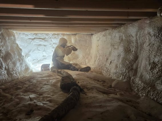 An installer from South Central Services insulating a crawl space with closed cell spray foam.